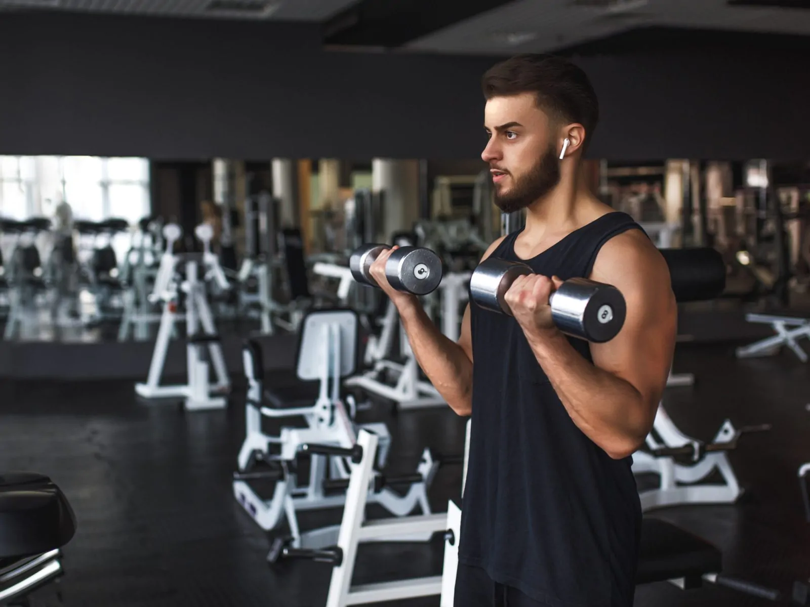 Muscular young man working out in gym doing exercises with dumbb The Growing Importance of Nutrition and Fitness